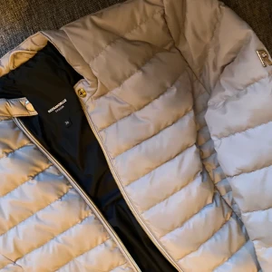 Rock and blue jacka  - Jättefin lättviktsdunjacka från rock and blue. Beige med gulddetaljer. Använd en gång.  Storlek 36.  Nypris 1650:- 