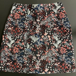 H&M kjol  - En blommig jacquard minikjol från H&M i strl 36. I helt ny skick. Har endast används 1 gång.