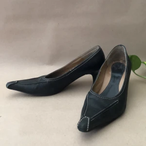 Rockiga myggjagarpumps i svart skinn, 50-talsstil - Sjukt balla pumps! Inköpa tidigt 2000-tal, sparsamt använda. Perfekt att dressa upp ett par loose jeans med. Strl 38,5 men har använts av en som har strl 37,5. Ca 5cm klack. 