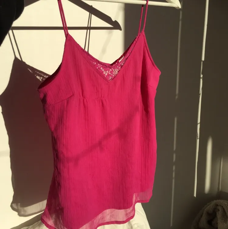 Ett rosa linne med spagetti band. Jag älskar tyggen som bryter i ett mesh material. Pris: 80kr . Toppar.
