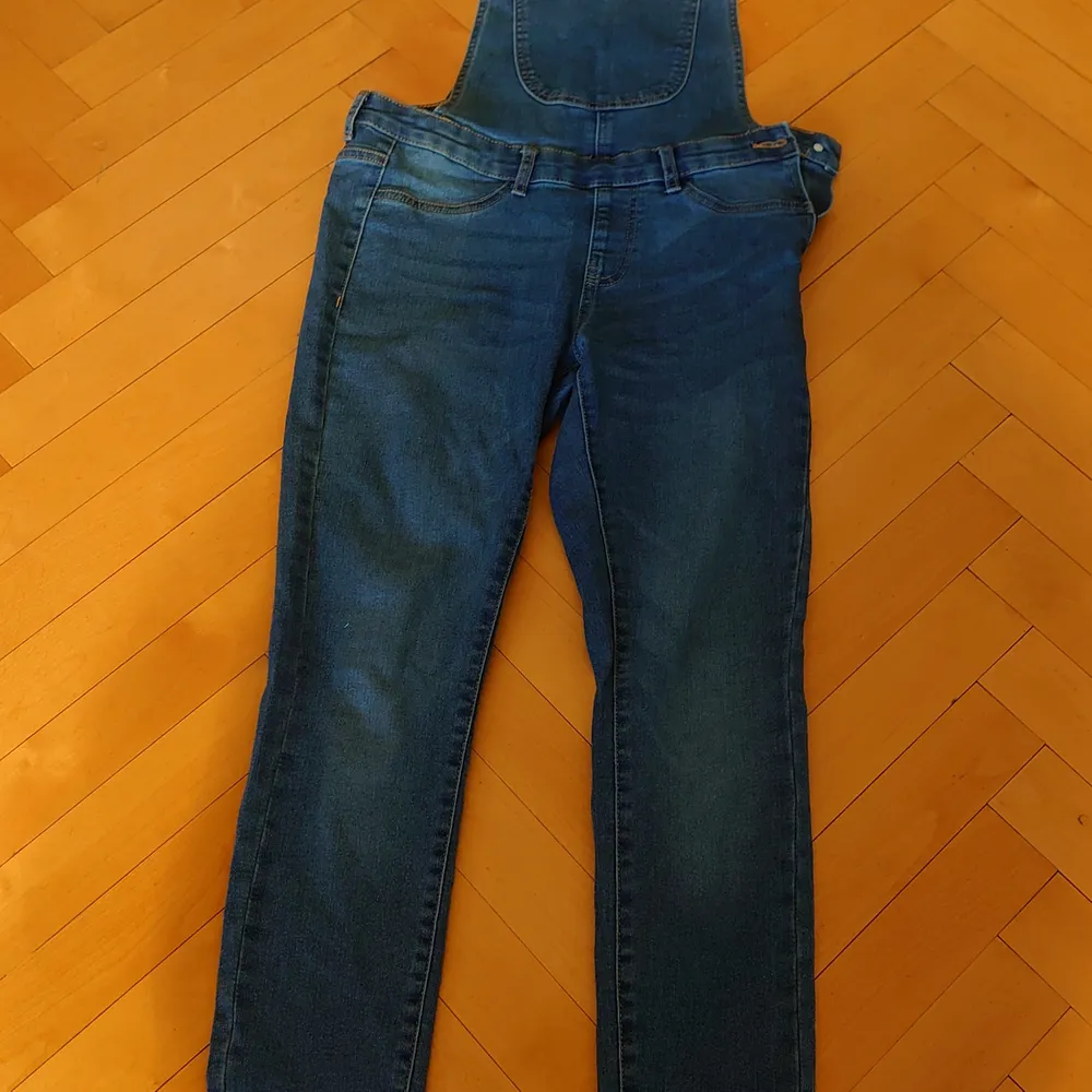 Jeans hängselbyxor i ett väldigt stretchingt material. Modellen på byxorna heter Skinny dungarees. Super söta och praktiska, då man kan använda de till alla plagg. Har en dragkedja och knapp på sidan men även justerbara axelband. 70-80-90s is back. Jeans & Byxor.
