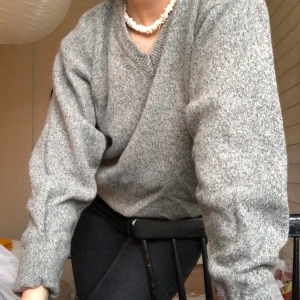 Grå stickad tröja - Grå v-ringad, stickad tröja. Köptes second hand med lapp kvar på. Endast använt den en gång. Står att det är storlek XL men skulle nog mer säga att den är S/M. (PS. Har ej hunnit väga klädesplagget ännu, därför är priset för frakt inte helt säkert)