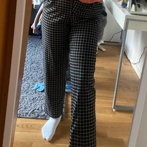 Rutiga kostymbyxor - Rutiga kostymbyxor från Monki, högmidjade med knapp och dragkedja i fram. Använda några gånger men är i väldigt bra skick. Frakt ingår i priset