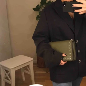  - Militärgrön axelbandsväska med silvriga metallprickar längsmed kanterna. På väskans ena kant är färgen lite uppskrapad men det syns knappt (vid intresse skickas fler bilder privat). Möts i Stockholm annars står köparen för frakten🐍🌳🌱