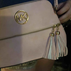  - Fejk Michael Kors väska. Väskan köpte jag för 450 kr. Den är som i nyskick, har inte använts. Färg:Smutsrosa. Vill du veta mer så är det bara att kontakta!  Har inget kvitto. Står inte för leveransen 