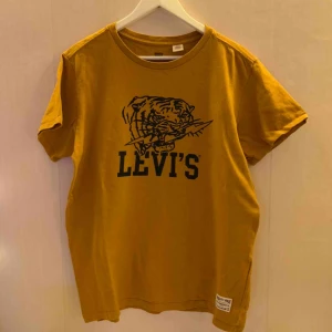  - Senapsgul t-shirt från Levis. OBS det är storlek M i mansstorlek.  Jag kan mötas upp i Borås, eventuellt Göteborg, annars står köparen för frakten.  