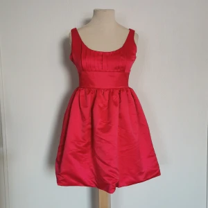 Klänning - Ceriserosa klänning. Märke: Jeane Blush från Nelly. Storlek: M. Skick: använd en gång så i mycket fint skick (har endast sytt upp axelbanden ca 2 cm då dessa var för långa för mig). Pris: 150 kronor eller bud. Frakt: Betalas av köparen. 