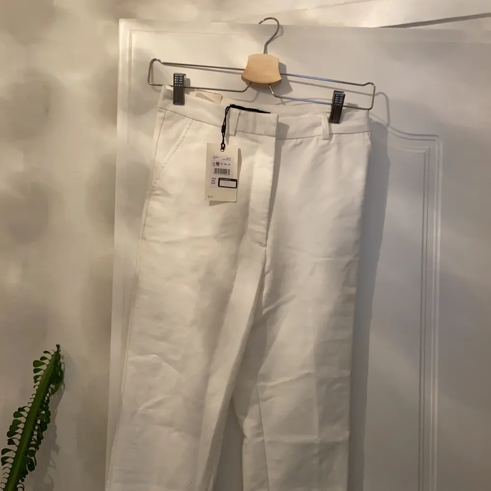 Säljer ett par vita kostymbyxor från Bikbok som är i storlek 36. Byxorna har aldrig använts förutom på bilderna och har därför kvar prislappen💘✨. Jeans & Byxor.