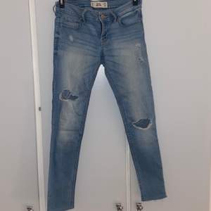 Ljusblå slitna Hollister jeans, strl W26 L29, dock avklippta ungefär 1 cm. Färgen speglas bäst på bild nummer två. 120+ 60kr frakt