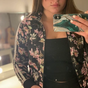 Adidas kofta storlek 34 - Säljer denna superfina blommiga adidaskofta som tyvärr inte kommer till användning längre. Använd sparsamt men trycket på ryggen har spruckit lite (se sista bild) frakt tillkommer.