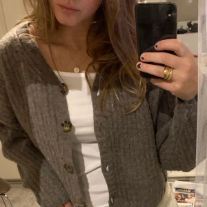 Kofta / stickad tröja - Så fin stickad kofta ifrån weekday. Ljusbrun / grå höstig färg. Storlek XS, är lite oversized och sitter väldigt snyggt! Använt fåtalgånger, fint skick! Köparen står för frakten. Ordinarie pris 600kr.