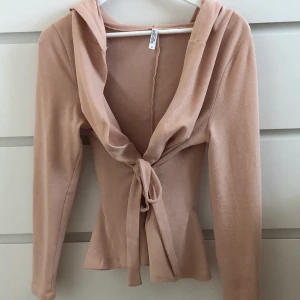 Puderrosa kofta i storlek M - En puderrosa kofta med band & luva i storlek M. Från Bubbleroom, nästan aldrig använd. 