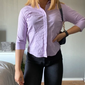 Lila skjorta - Figursydd lila skjorta med trekvartsarm som ska vara storlek L enligt lappen men är max en M, skulle nog sträcka mig till S till&med. (Jag har vanligtvis S) 80kr + frakt