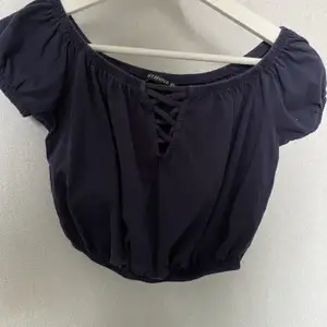 Croptop, off-shoulder, detalj framme, sitter åt i midjan. Blir en liten ballong liknande look. Kommer inte till användnign längre, köpt för ca 1 år sedan. 