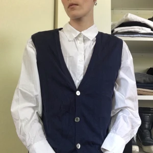 Väst från Filippa K - Väst från Filippa K.  ??Storlek: L( funkar även på S-M ??Material: 100 % bomull ??Skick: Sista knappen saknas annars inget att anmärka på. Sparsamt använd. Se bild för knappen.  ??Hund finns i hemmet men inte på kläderna. Skickar egenpaketerat med frimärken. Filmar när jag lägger på lådan.