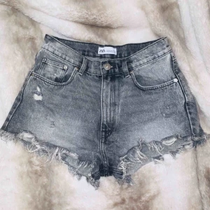  - Super snygga ”High Rise Distressed” jeans shorts från Zara SS19 kollektionen. Oanvända. Storlek 34/XS.  Betalning via Swish, bjuder på frakt vid snabb affär! 