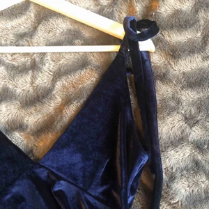  - Oanvänd partytopp i mörkblå sammet från NA-KD. Jättefin och bra passform, färgen framkommer bättre på bild 2. ❣️ Prislappen är fortfarande kvar och nypris hade varit 349 kr. Axelbanden med rosetter går att knyta som man själv önskar. ✨