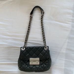 Michael Kors väska - Svart väska med silver detaljer från Michael Kors, man kan antingen ha dubbla band för att ha den kort på axeln eller ett långt band för att ha den som en crossbody bag.                   Nypris: +3000 kr, bud från 500 kr 