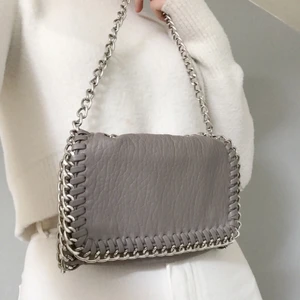 Axelväska  - Axelväska i grå läderimitation i nyskick. Endast använd ett fåtal gånger. Nypris:450kr💕 Går att fölänga kedjan. Pris: 130kr+frakt