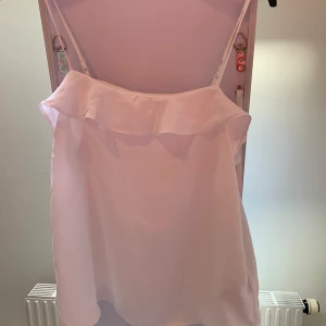 Vitt linne med volanger - Simpelt vitt linne med justerbara band vid axlarna. Använt 2-3 ggr ungefär