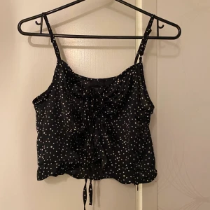 Prickig topp från nelly - Jättesöt prickig topp köpt med snörning som kan justera hur djup urringning man vill ha. Strl 36. Använd ett fåtal gånger 