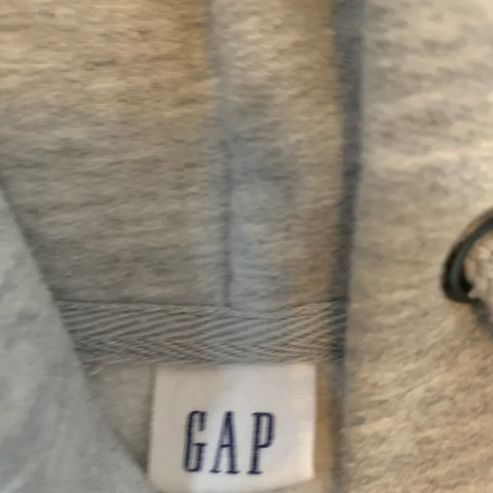 En snygg grå hoodie med dragkedja ifrån GAP. Mycket fint skick och inte använd många gånger alls pga för liten för mig. Köparen står för frakten🥰. Hoodies.