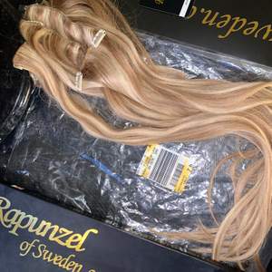 Aldrig använt äkta löshår med orginalförpackning.  60cm äkta hår från Rapunzel of Sweden i färgen ”summer blonde/M7.4/8.0” clip on set med 7 delar  Nypris: 1500kr