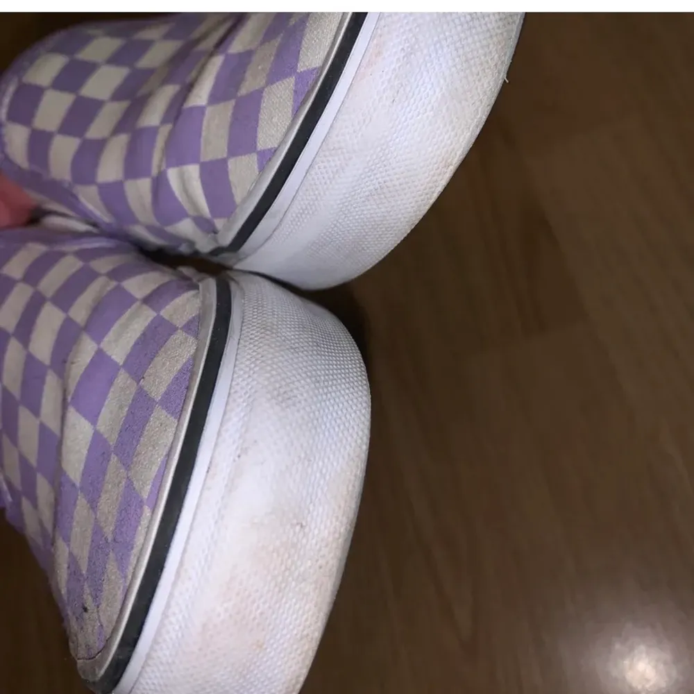 Ett par lila slip on vans, endast använda ett par gånger under våren/sommaren. Den vita sulan är lite ”smutsig” på visa ställen men annars fint skick. Frakten är inräknad i priset, nypris 750 kr.. Skor.