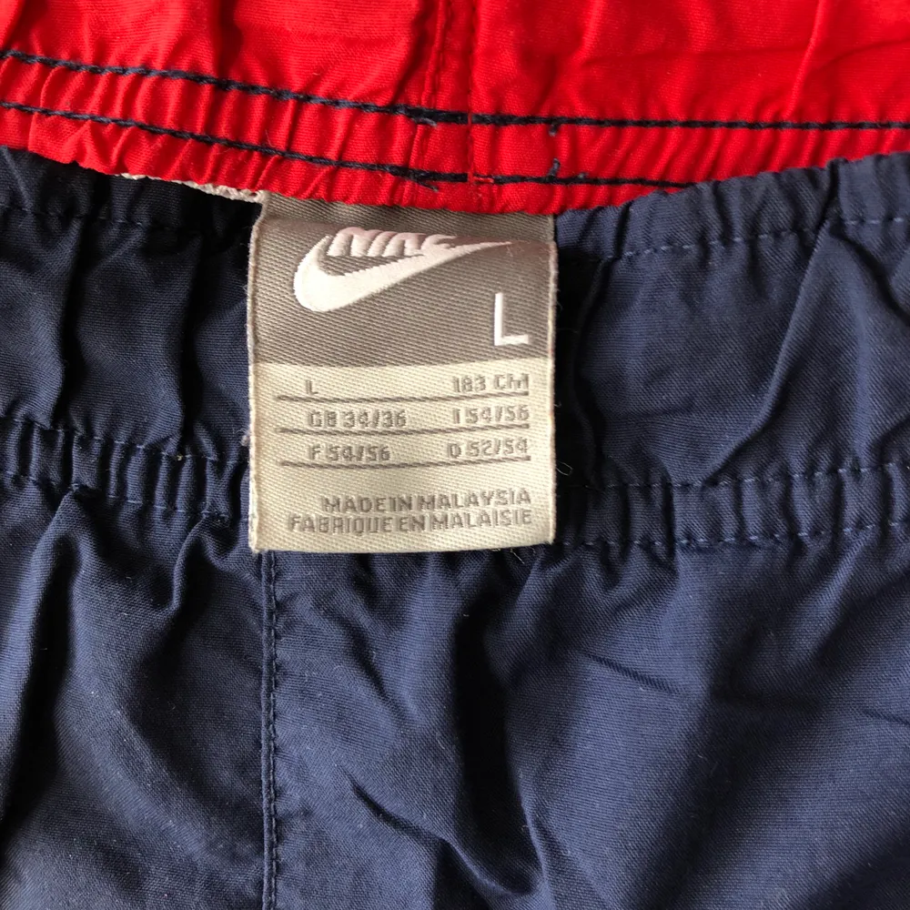 Rödblåa ”tränings”shorts från Nike. Vintage men gott skick. Passar L-XL. . Shorts.