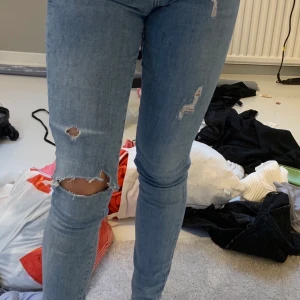 Blåa jeans - Blåa jeans, slitna/hål på knä. Passar storlek xs-s