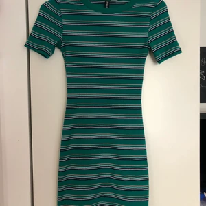 Jättefin grön randig klänning!! - Sparsamt använd stretchig tight klänning från hm! Så fina färger och kramar kroppen jättefint! Storlek 32 men passar upp till 36! 84kr inklusive frakt!!