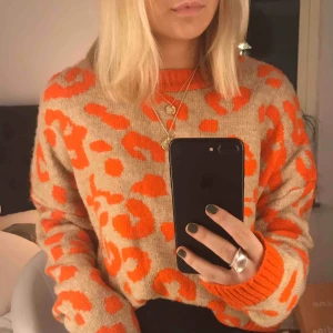  - En leopard stickad tröja med orange mönster, ifrån stradivarius. Köpt för 500kr Är i bra skick