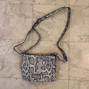  - Liten axelväska med ställbart axelband. Knappt använd.