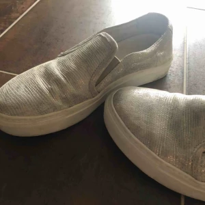  - Silvriga slipons skor.  Vet tyvärr ej vart dom är ifrån och är lite osäker vad det är för storlek, dessa är ungefär som storlek 37 i vans slipons. Köpta för ca 1000kr  Betalning sker via swish 