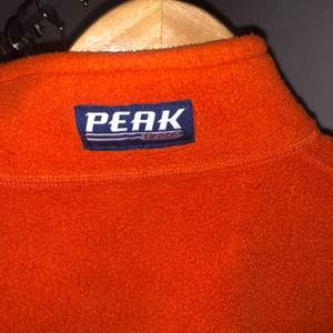 Orange half zip Fleece från peak performance! Nyskick, inköpt vintage. Står S men är mer åt XS i storleken, beror på hur man vill att den ska sitta. Porto tillkommer, 63kr!:)