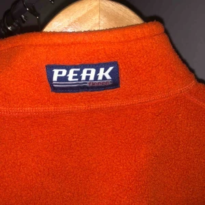  - Orange half zip Fleece från peak performance! Nyskick, inköpt vintage. Står S men är mer åt XS i storleken, beror på hur man vill att den ska sitta. Porto tillkommer, 63kr!:)