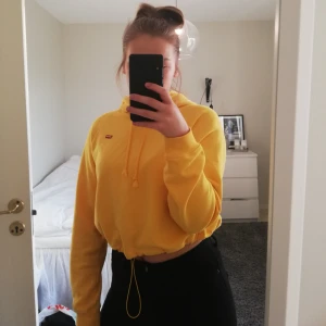 Hoodie  - Gul hoodie från Levi's! Croppad och går att justera med band i midjan. Knappt använd 