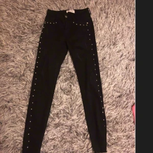 Svarta jeanse med snygga detaljer  - Jätte snygga svarta byxor från Raglady med slitning längst ner , endast använd 1 gång 