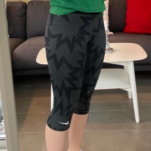Nike tights strl S - Sporttights från nike. 3/4 långa, slutar strax under knät. Svarta med snyggt mönster