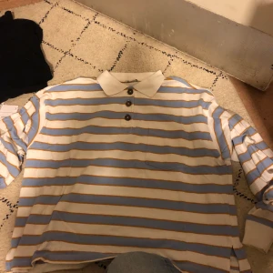 Långärmad, randig tröja med knappar - Långärmad, randig tröja med knappar från monki. Köpt förra året men endast använd 3 gånger. Originalproduktioner 250kr