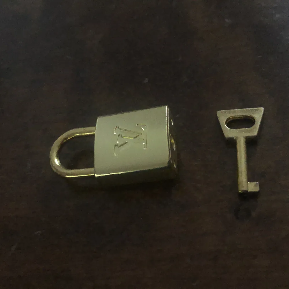Louis vuitton lås + nyckel, inte äkta men i mycket fint skick och ser äkta ut. Den är guldig. Perfekt att ha som berlock till ett halsband eller på en väska. I mässing.. Accessoarer.
