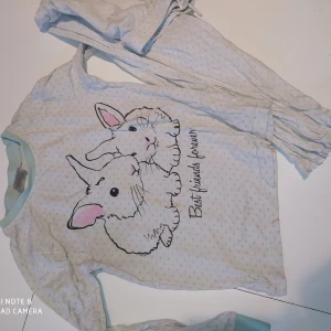 Gullig kaninpyjamas 110/116  - Liten fläck mitt på. Det svarta glittrar. Vit med mintgröna prickar,söta volangkanter!