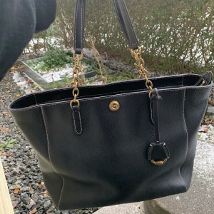 (Äkta) Ralph Lauren chain tote bag - Väldigt rymlig med sidoficka på utsidan, stort fack + 4 mindre fack på insdian, ett med dragkedja. I nyskick pga knappt använd, dustbag medföljer. Nypris lite dryga 3000 om jag inte minns fel. Priset kan eventuellt diskuteras. (Frakt tillkommer, antingen 66 elr 99 kr men måste dubbelkolla)