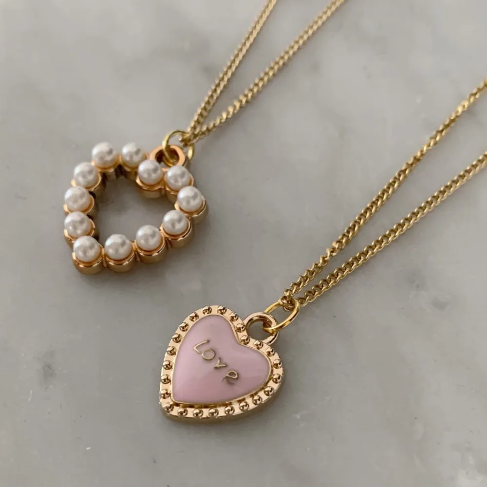 Hjärthalsband för endast 110kr/st 🧸✨ Halsbanden finns i två olika motiv: med pärlor och i rosa med ordet ”LOVE” (som dessutom kan vändas på för en hel guldsida!) . Accessoarer.