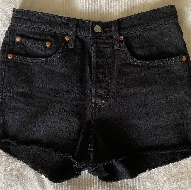 Säljer ett par i princip oanvända levi’s jeansshorts i svart färg. De knäpps med knappar, har fickor fram och bak och är som tredje bilden visar inte för korta som många shorts kan vara. Sitter avslappnat men är tyvärr lite för stora för mig.    Postar med postnord spårbart. Hör av er vid frågor!. Shorts.