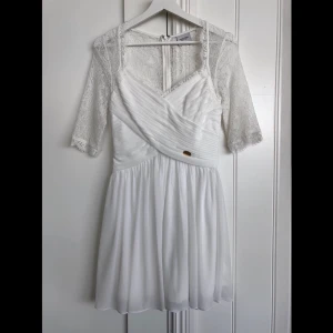 Studentklänning - Säljer vit, fin sommarklänning som passar både till student och skolavslutning. Från Chiara Forthi beställd från bubbleroom. Endast använd en gång vid en skolavslutning. 
