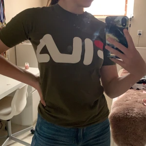 Grön fila t-shirt - Grön t-shirt från fila. Sparsamt använd och i gott skick(förutom stället jag råkade smälta sönder med strykjärnet, se bild 2)