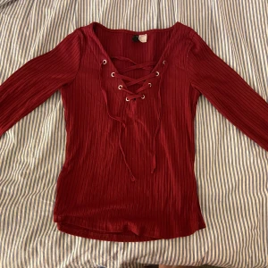 Röd tröja med snörning - Basic ridtröja med snörning köparen står för ev frakt 