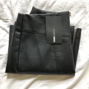 Fashionnova skjol i fakeläder  - Snygg Fakeläder kjol med dragkedja i mitten, prislappen sitter kvar och den är aldrig använd, säljer pga att jag råka köpa en storlek för stor, den slutar en bit över knäna när den sitter som den ska💕