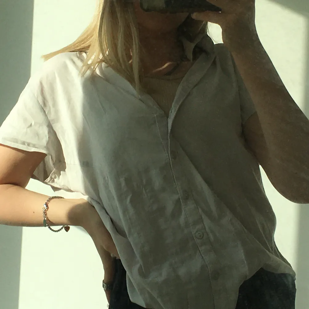 En jätte snygg vit/grå t-shirt skjorta, jätte skön på sommaren 🥰, Storlek 42 men passar även xs beroende på hur man vill att den ska sitta. Blusar.